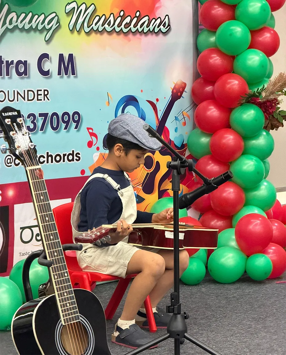 A student playing guitar at a CforChords showcase